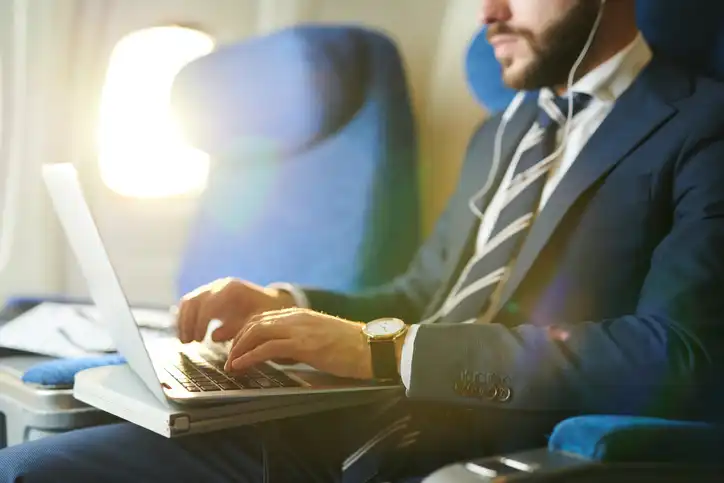 Business Traveler Working On Laptop During TVC Flight